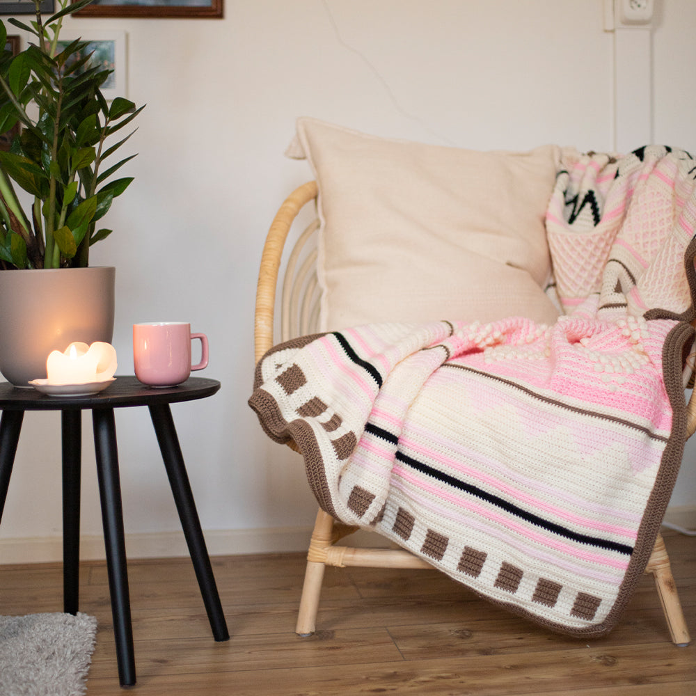 Droomdeken 6.0 in zachtroze en naturel over een fauteuil